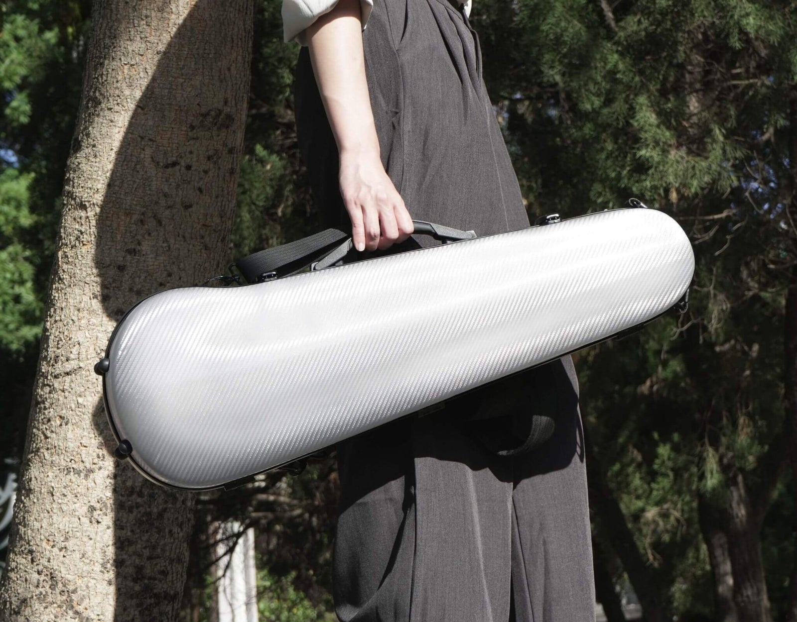 Silver Molto Neo shaped viola case carried by a person using the side handle